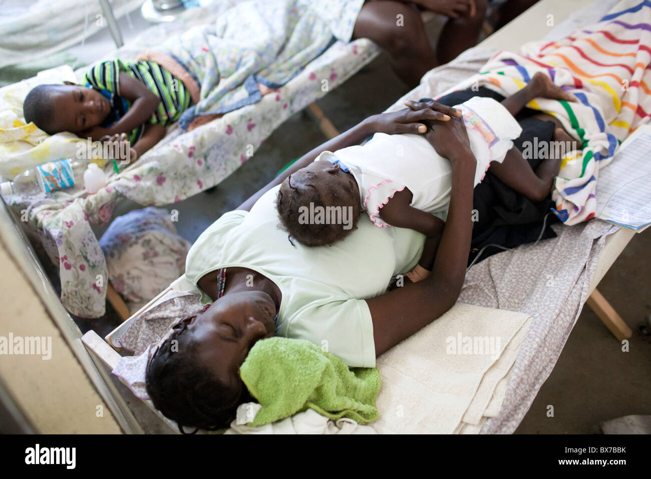 A woman sleeps with her child, who is sick with cholera, at the Hospital Albert Schweitzer Stock Photo