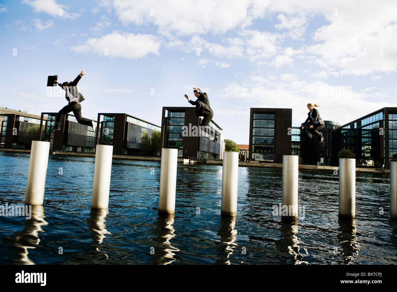 3 people jumping poles Stock Photo