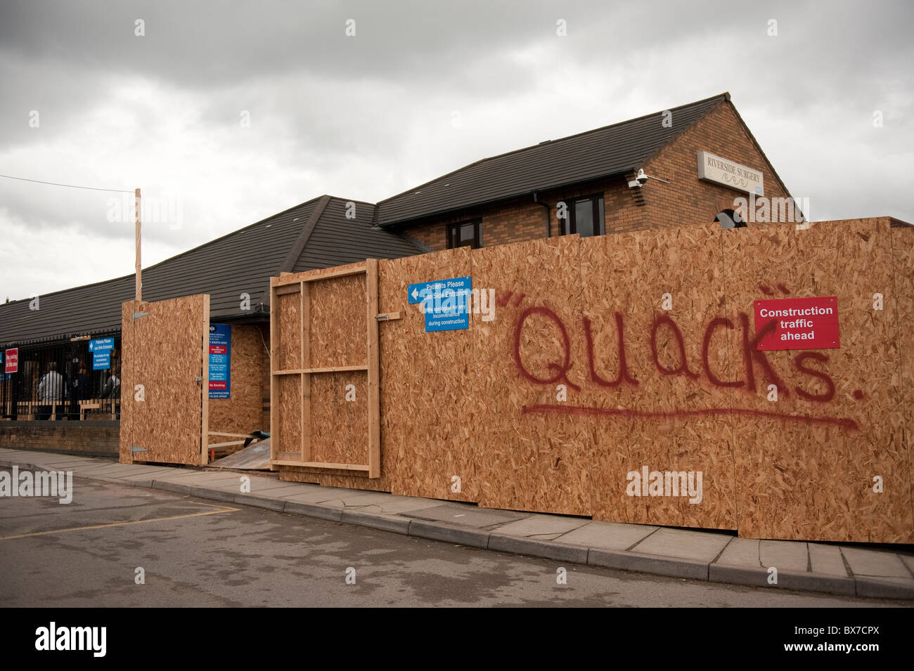 Graffiti on Construction Site Boarding Doctors Quacks Stock Photo