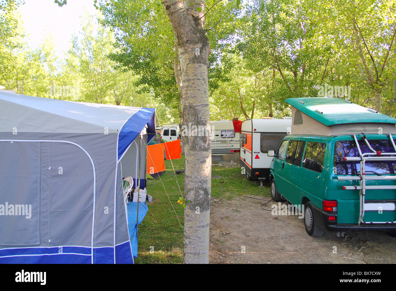 Camping tents caravan in green trees outdoor summer vacation Stock Photo