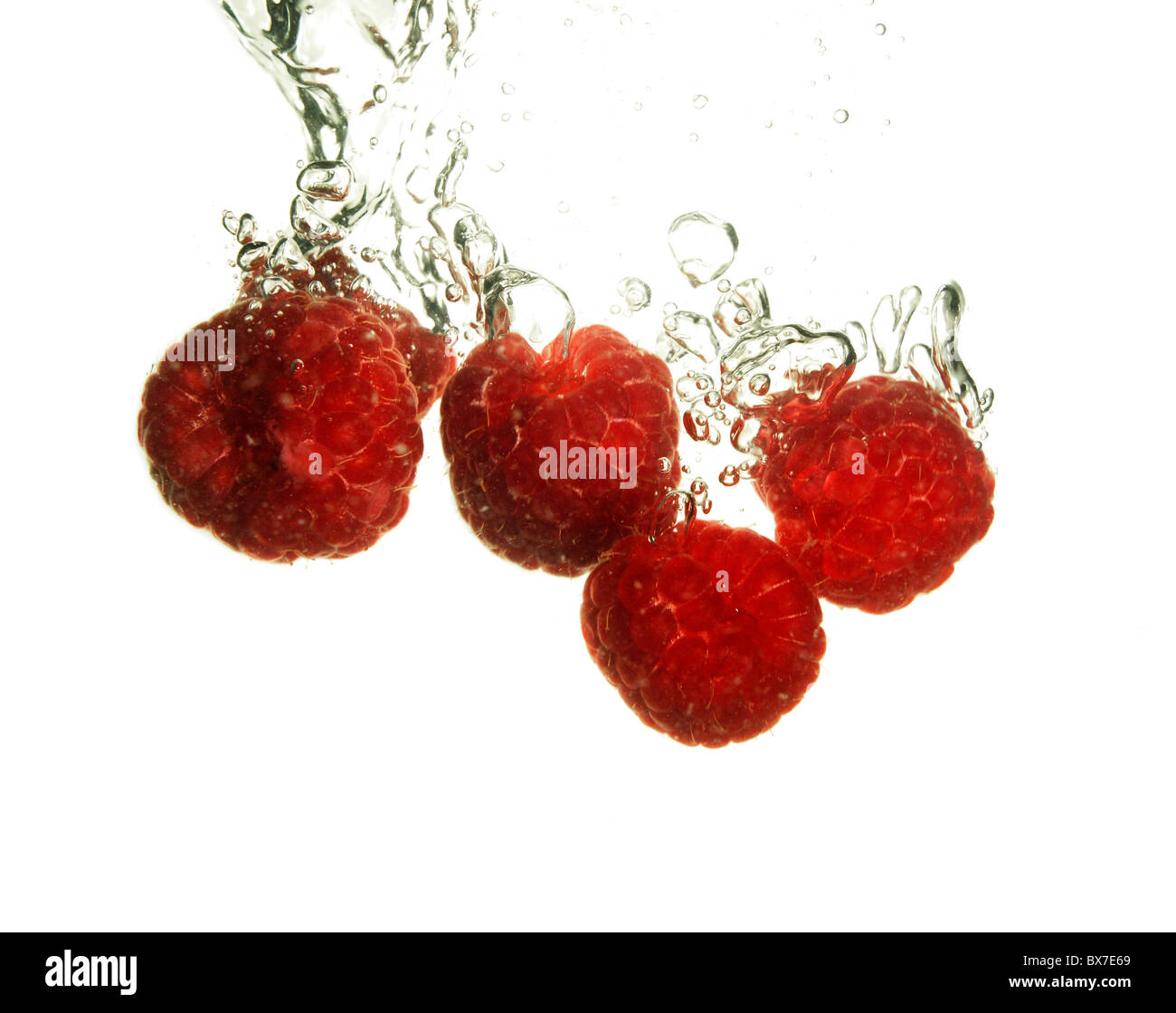 Splash of fresh raspberry to water with bubbles of air Stock Photo