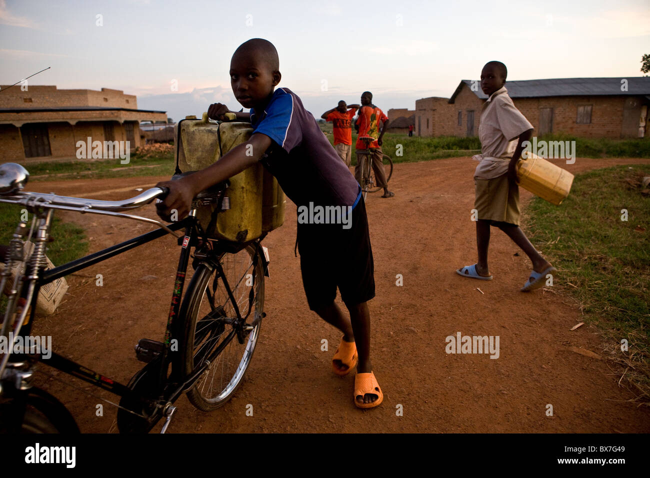Child carrying water on a bicycle in a village in northern Uganda, East Africa. Stock Photo