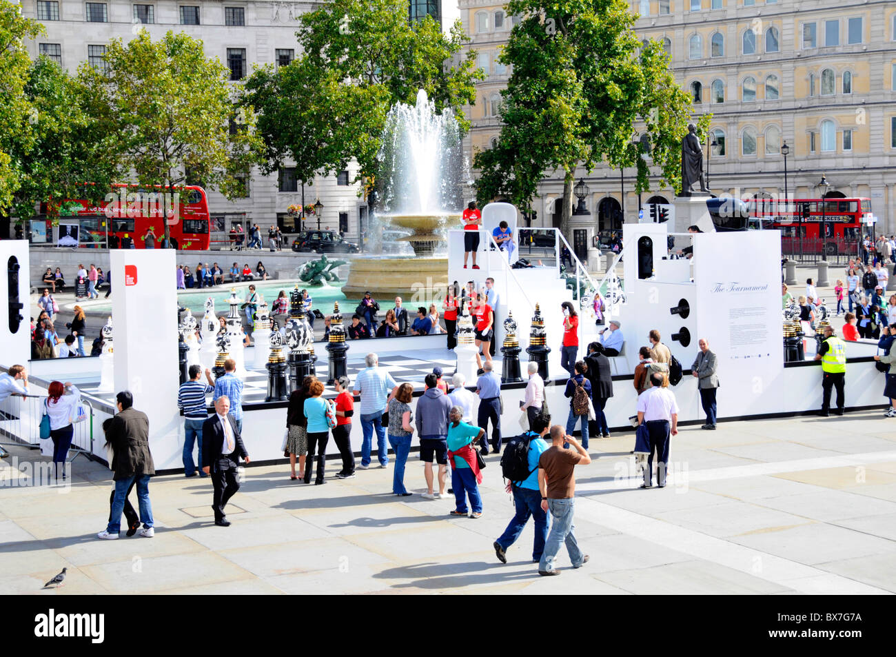 Tourists and visitors in Trafalgar Square with chess tournament using oversized pieces part of the London Design Festival event sunny day England UK Stock Photo