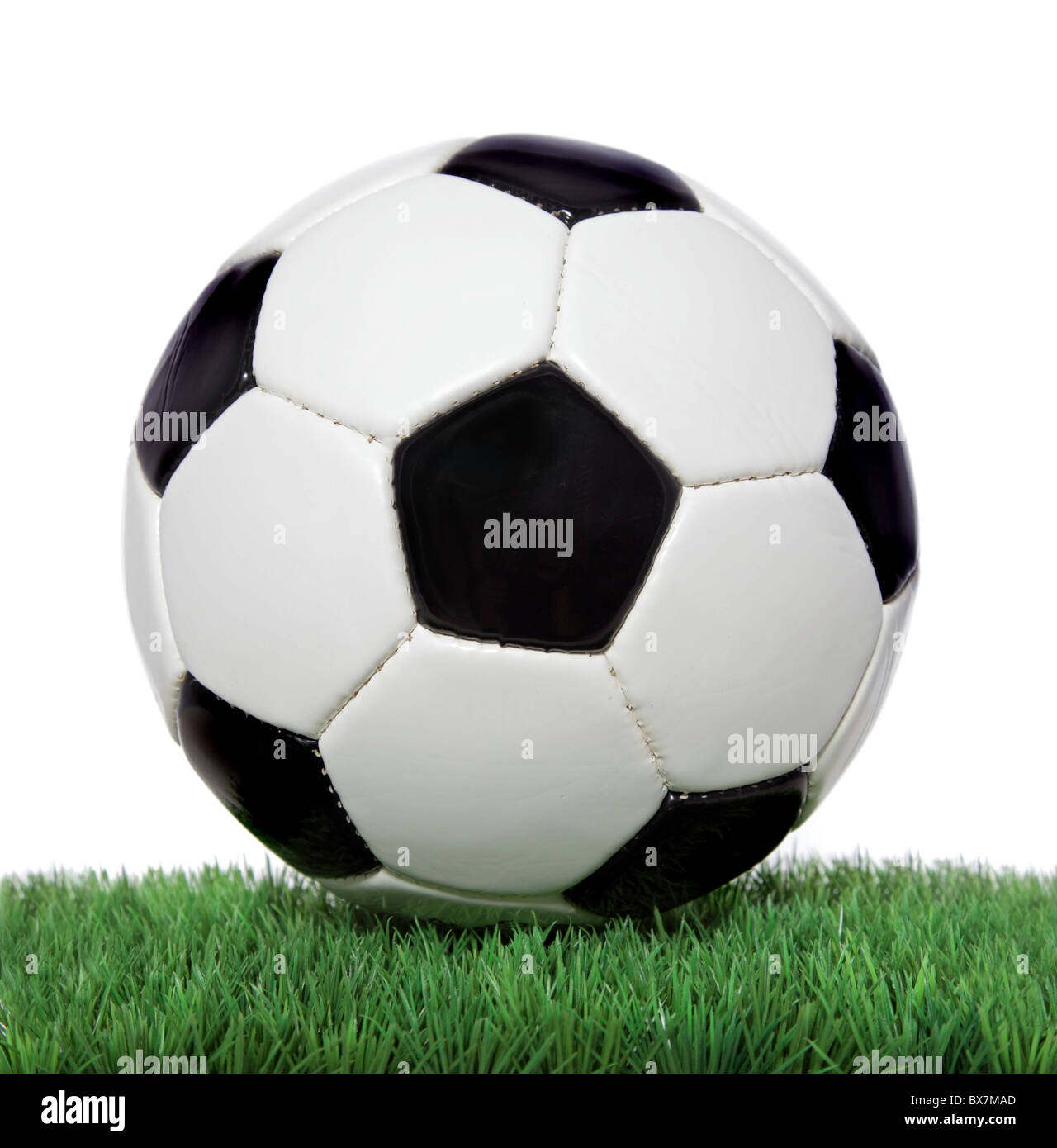 Soccer ball on green grass. All on white background. Stock Photo