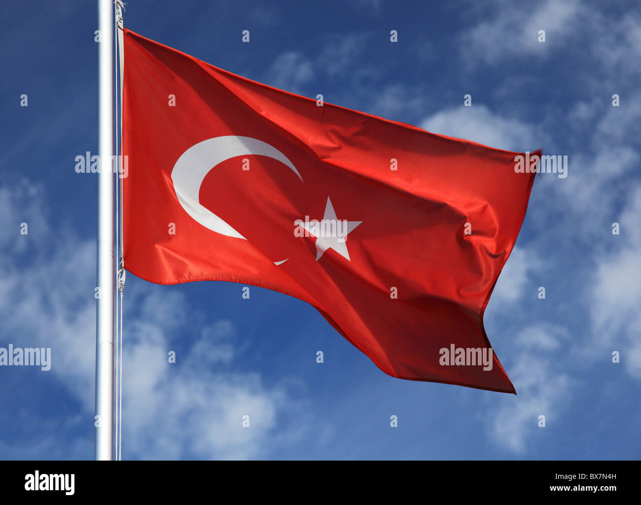 Flag of Turkey in front of light cloudy sky. Stock Photo