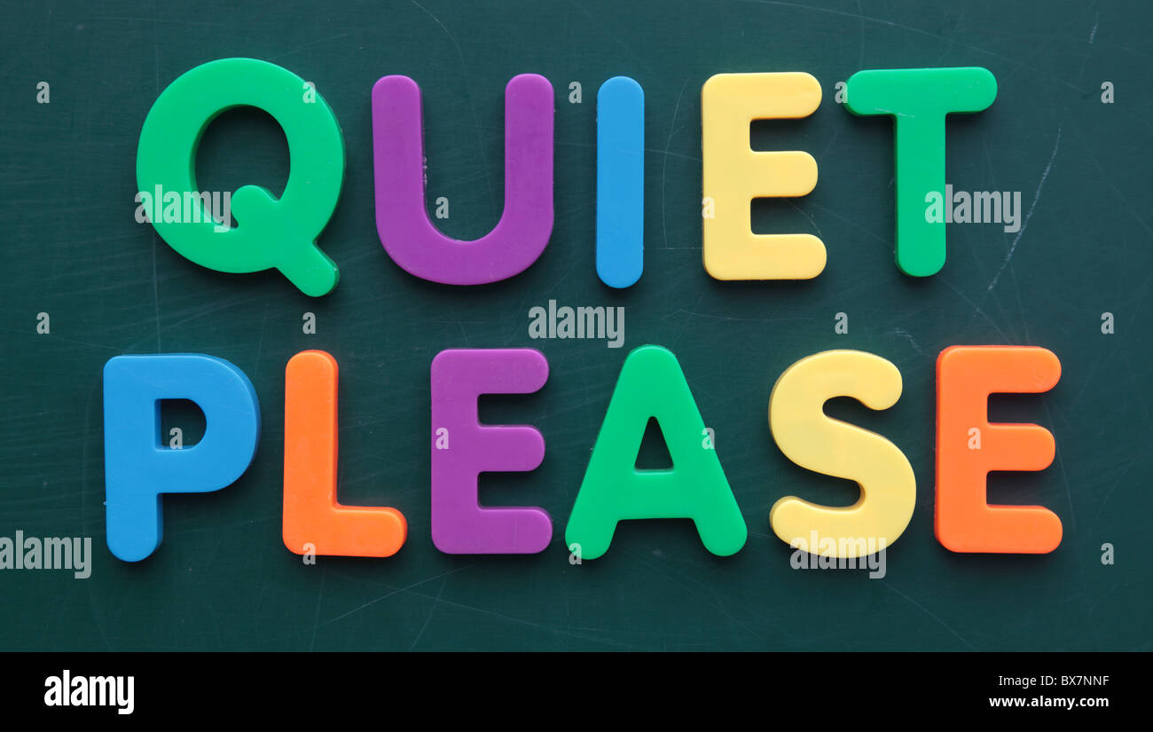 The term quiet please in colorful letters on a blackboard. Stock Photo