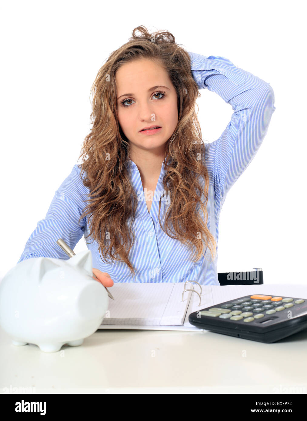 Portrait of a frustrated young girl doing her budgeting. All on white background. Stock Photo