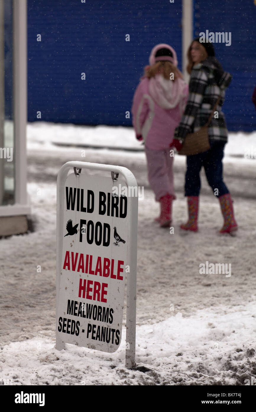 wild bird food sign on snow covered pavement Stock Photo