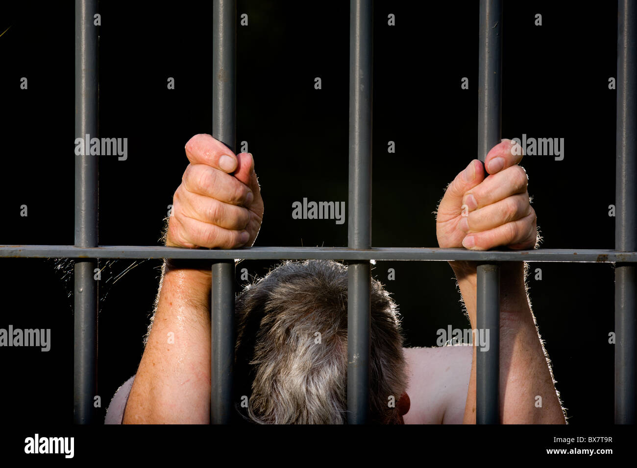 Offender behind bars Stock Photo - Alamy