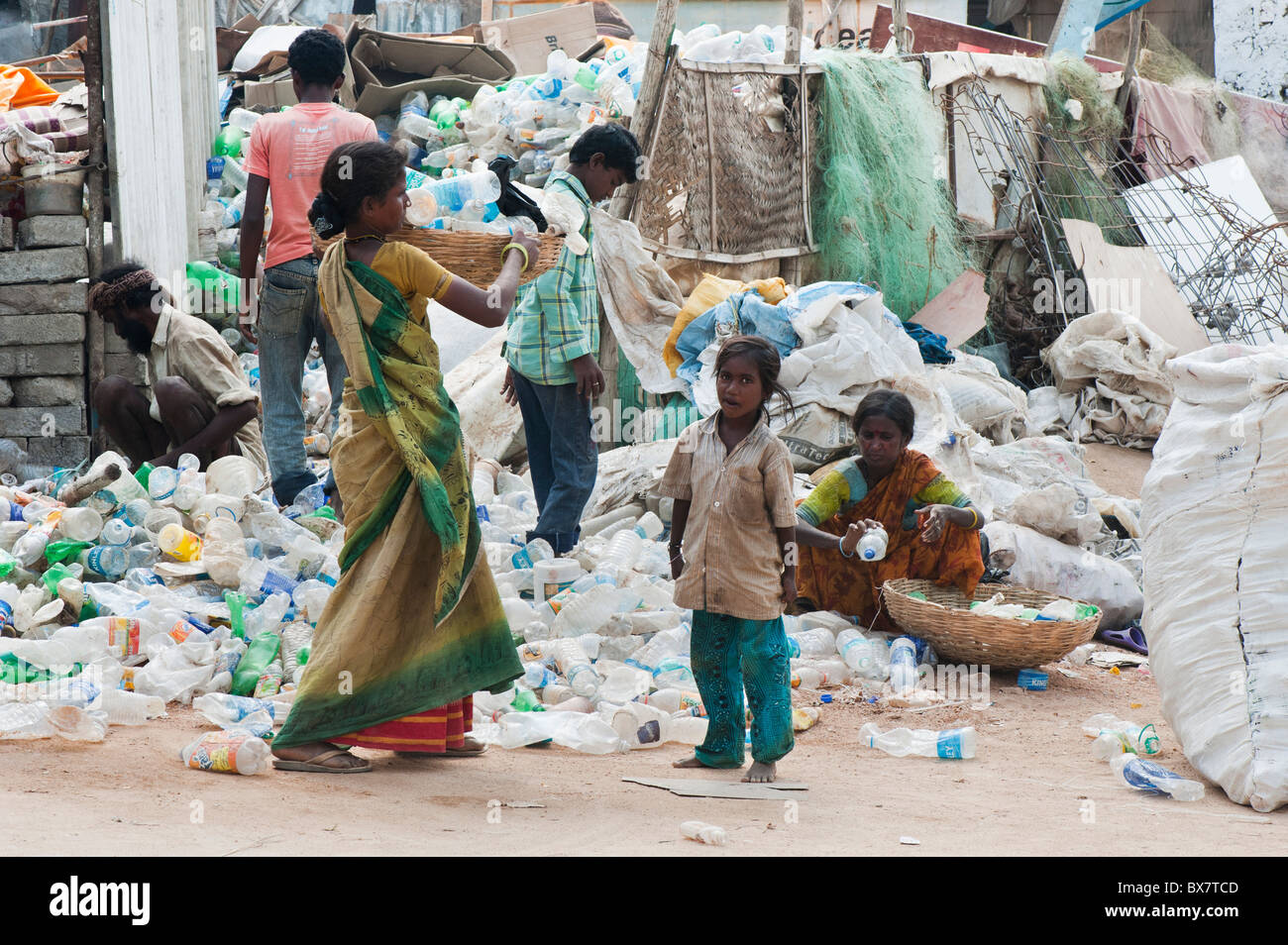 Poor lower caste street family recycling plastic bottles in an India street. Andhra Pradesh
