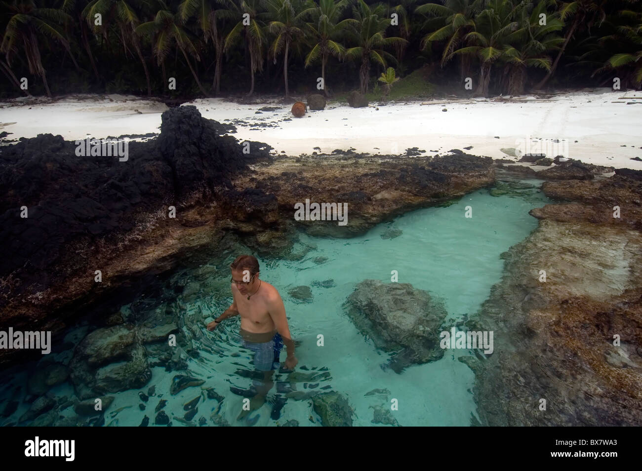 Man in rockpool at Dolly Beach, Christmas Island, Indian Ocean. no MR Stock Photo