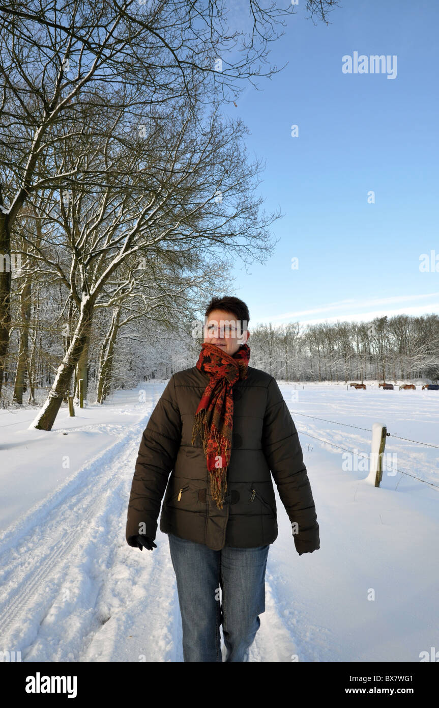 Senior keeping fit in winter time by walking in the snow Stock Photo