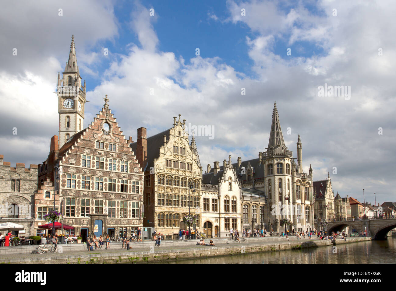 Ghent Graslei on the waterfront in Belgium with tourists sunbathing Stock Photo