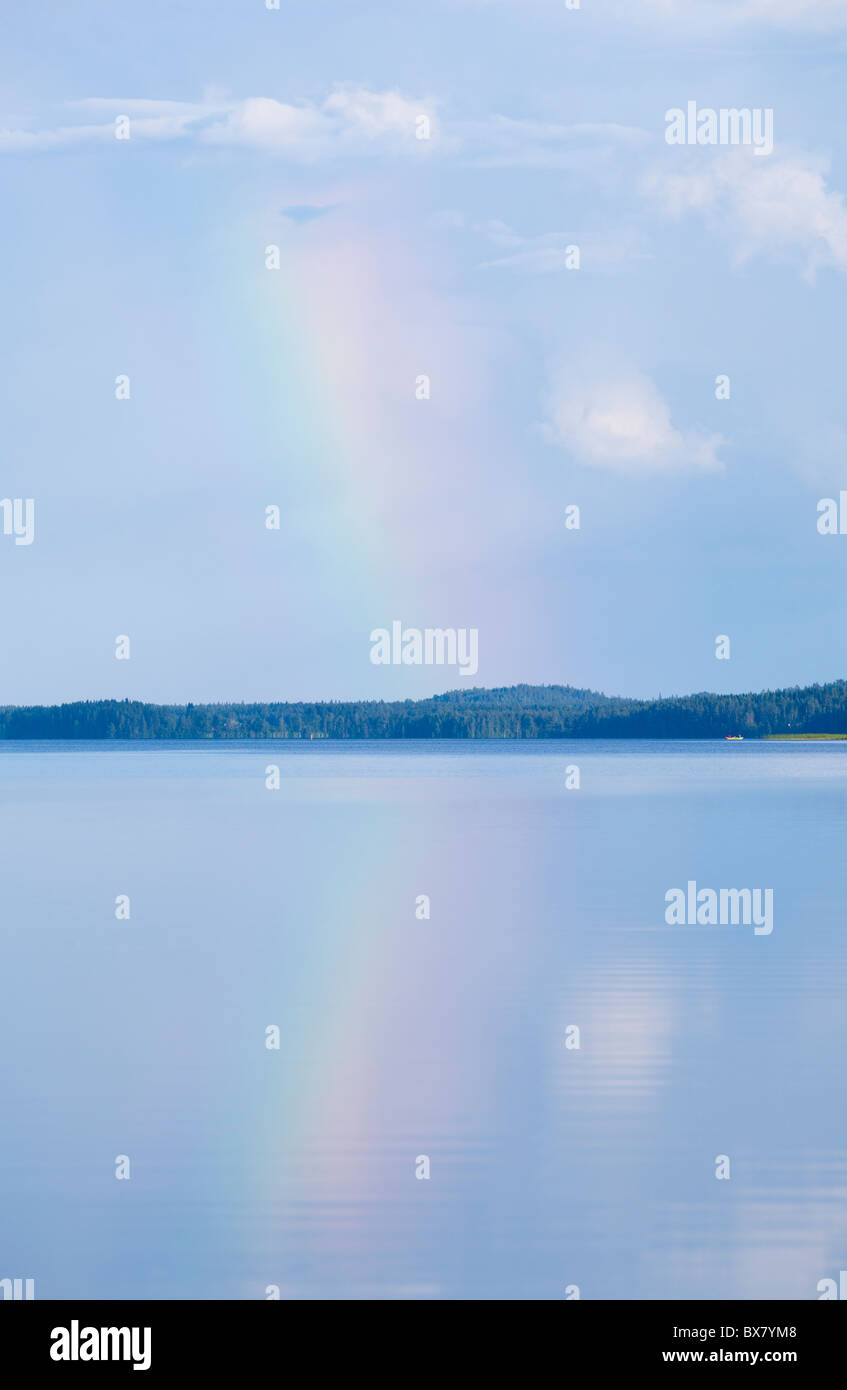 Rainbow over a calm lake , Finland Stock Photo