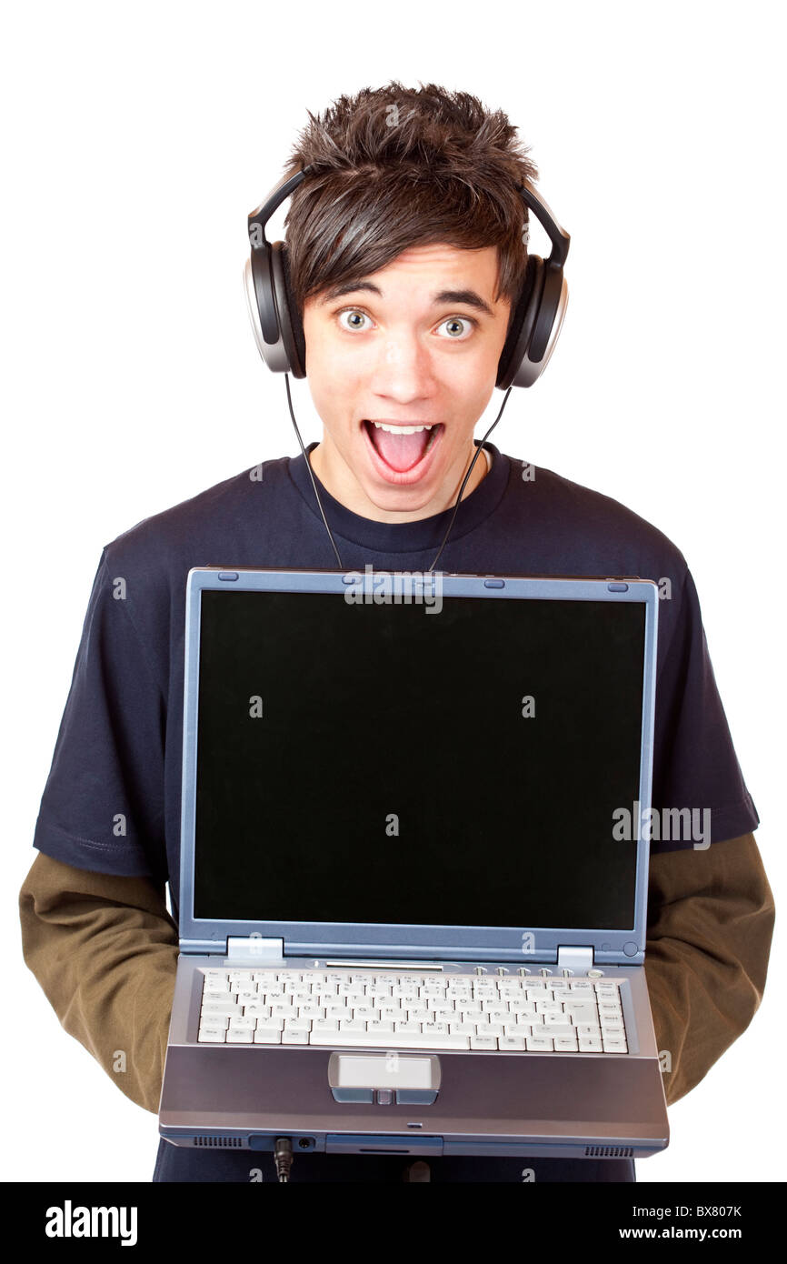 Male Teenager with earphones makes mp3 music download with computer. Isolated on white background. Stock Photo