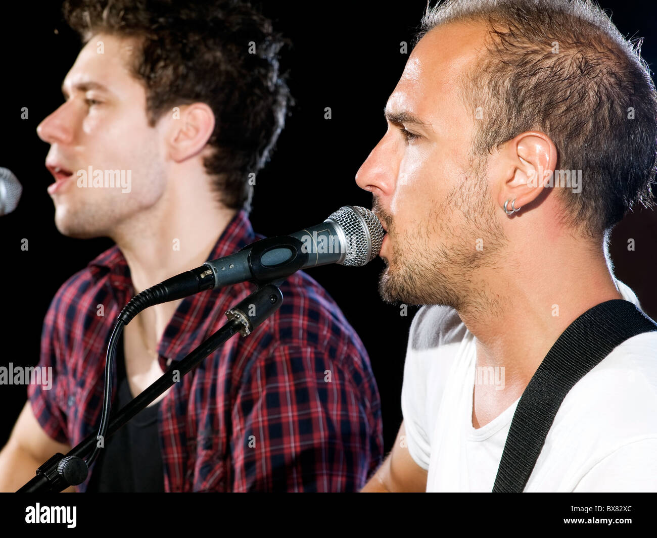 Profile view of two singers during a concert on stage Stock Photo Alamy