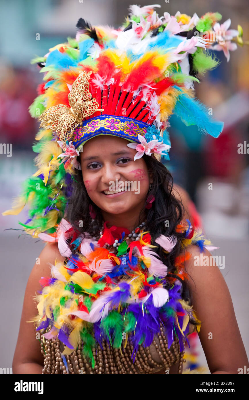 AMAZONIAN GIRL DRESSED UP IN TRADITIONAL PARROT FEATHERS COSTUME Stock
