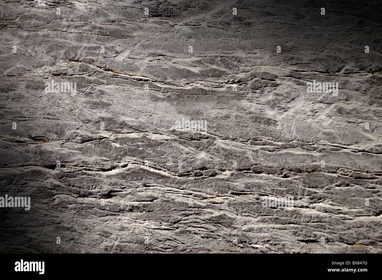 Cracked rock surface texture lit diagonally Stock Photo