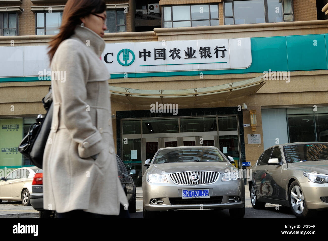 A woman walks past a branch of the Agricultural Bank of China in Beijing, China.12-Dec-2010 Stock Photo