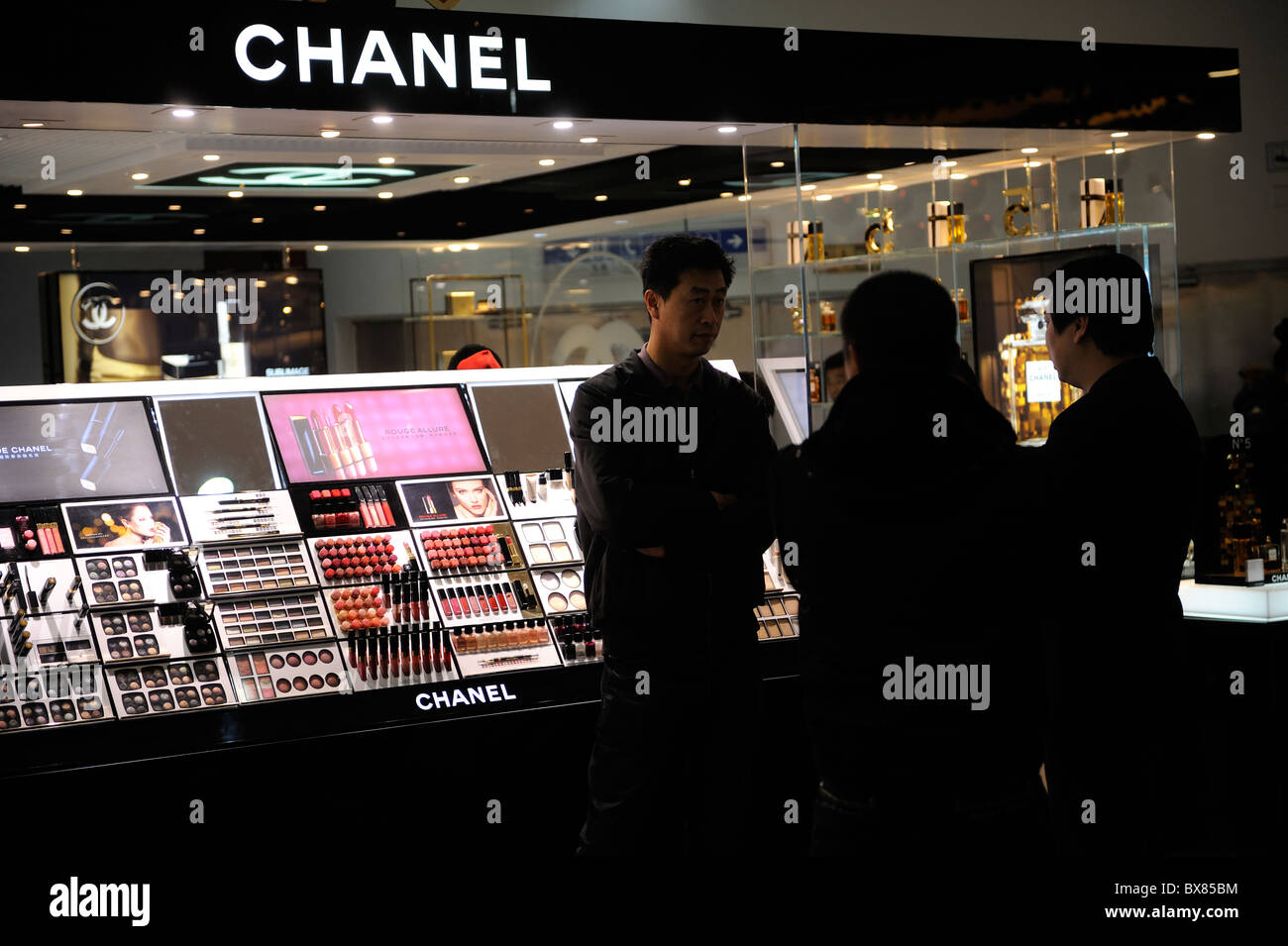 Chinese man stand near Chanel perfume stand in a shopping mall in Beijing,  China. 12-Dec-2010 Stock Photo - Alamy