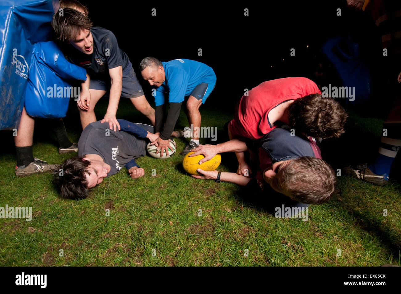 under 19’s doing rugby practice, with contact pads at night time Stock Photo