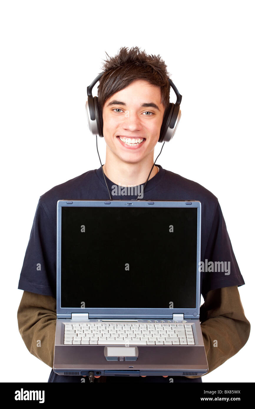 Male Teenager with earphones makes Internet mp3 music download at computer. Isolated on white background. Stock Photo