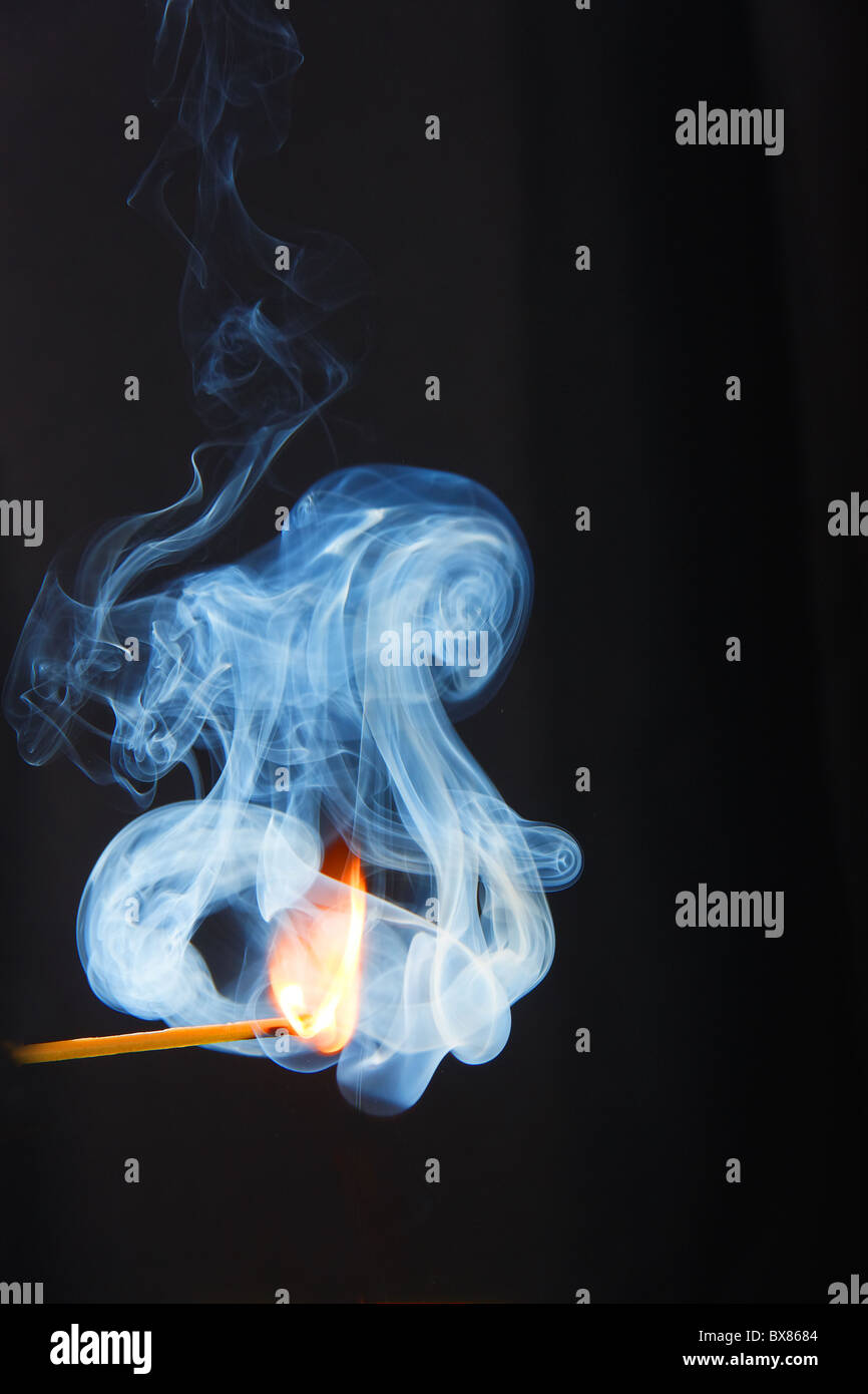 Fumée bleue de la flamme d'allumette sur fond noir Stock Photo