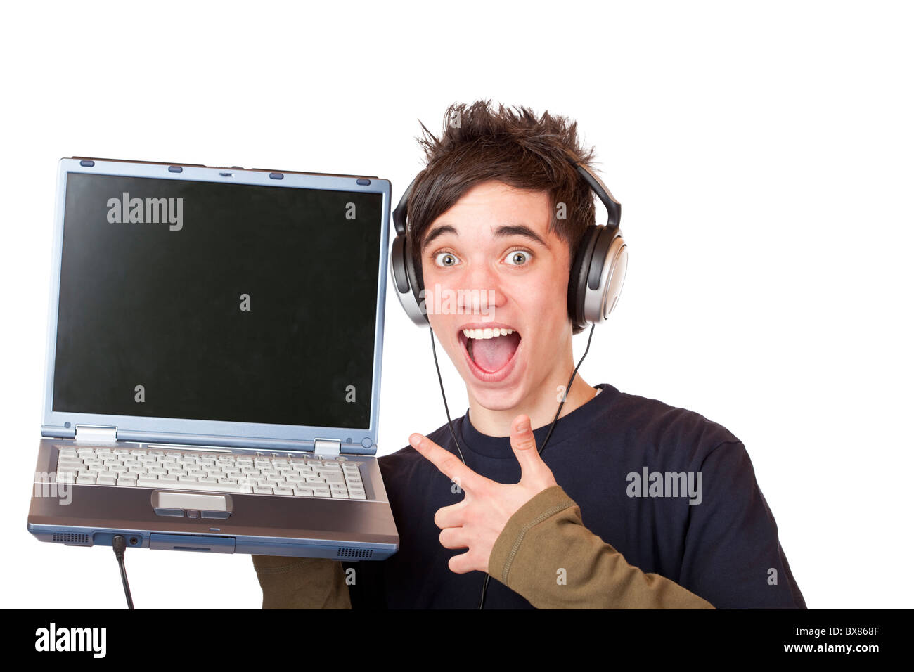 Male Teenager with earphones and laptop points enthusiastic at computer display. Isolated on white background. Stock Photo
