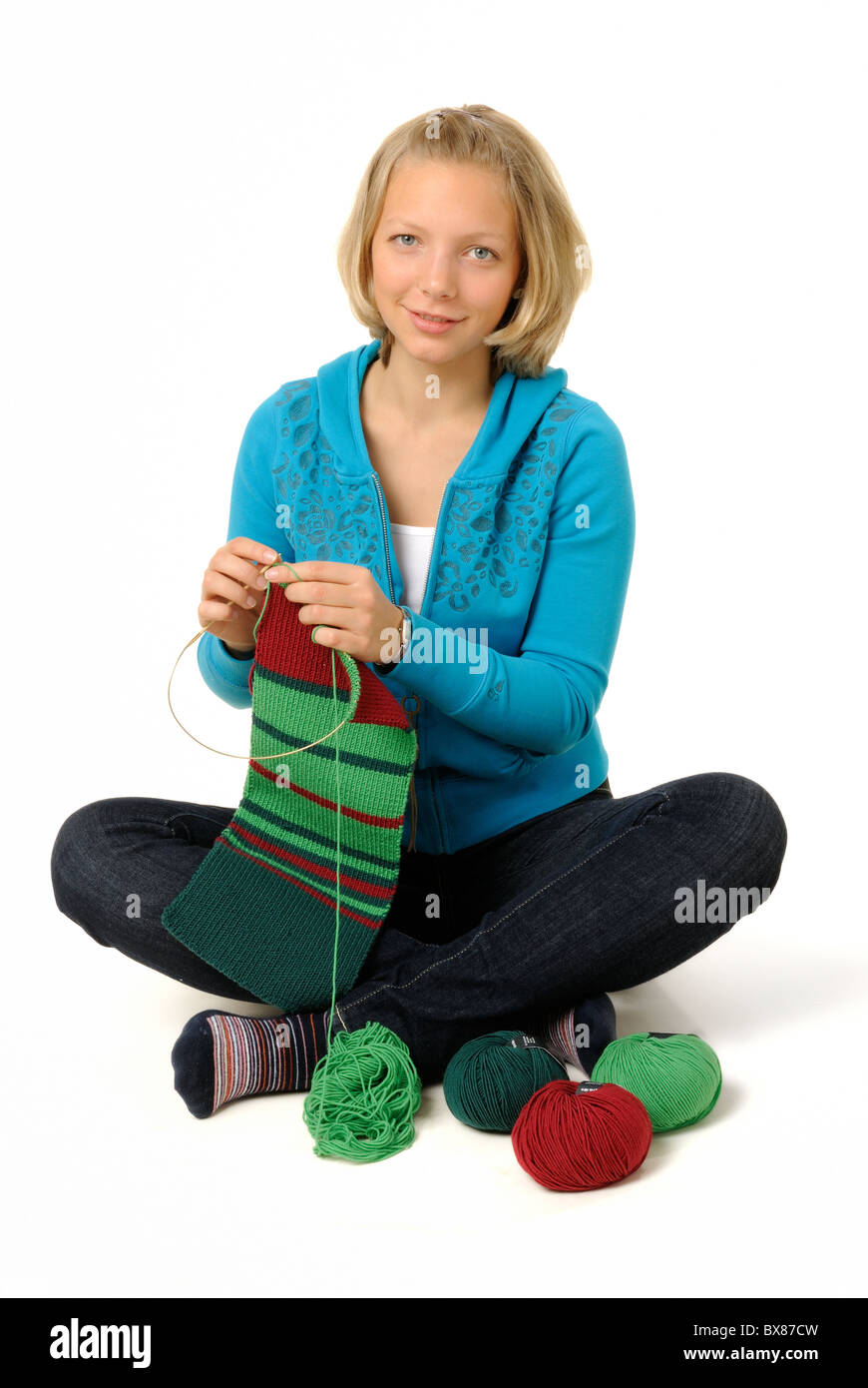 Young woman knitting scarf. Stock Photo