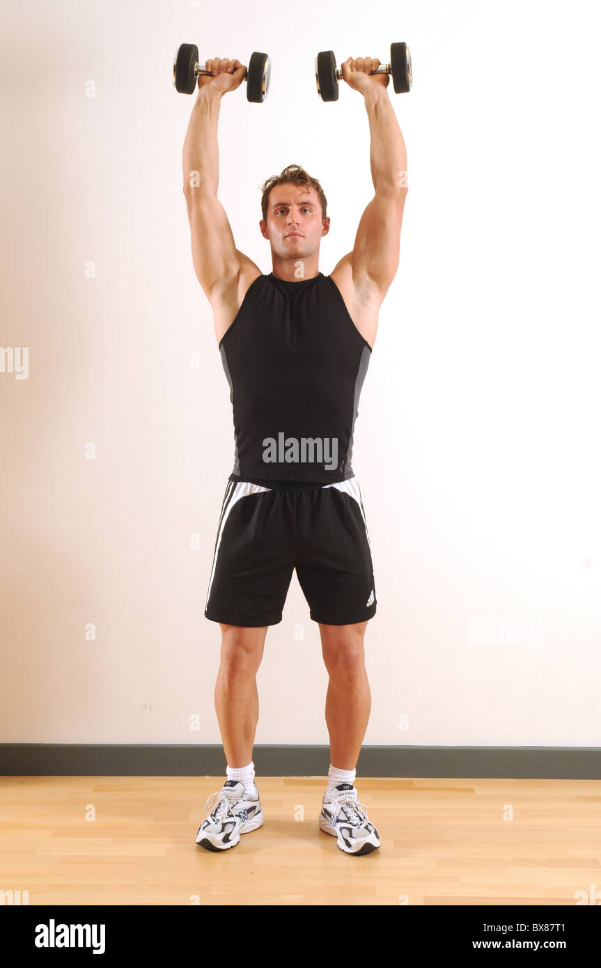 25-30 yr old male exercising in health club studio Stock Photo