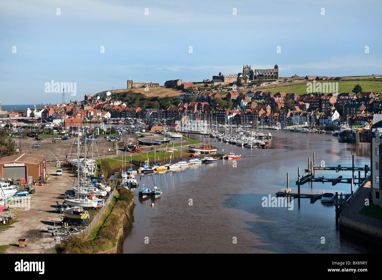The River Esk Estuary at Whitby, North Yorkshire on a sunny day. There are many sailing and motor boats berthed on the river Esk here. It is sunny. Stock Photo