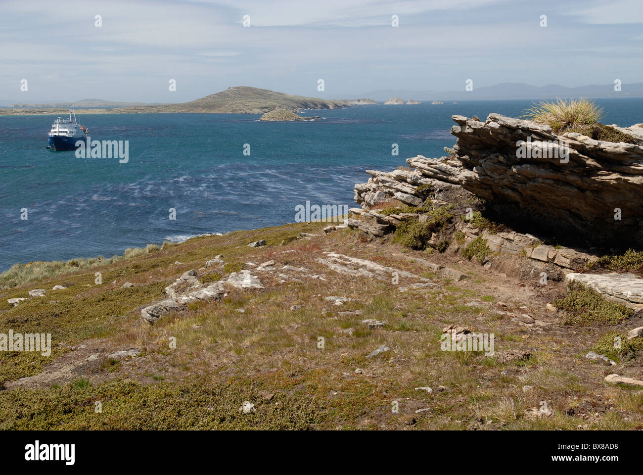 Rocks at Port Pattison, Carcass Island, and the expedition vessel m/v Plancius on anchor in the bay Stock Photo