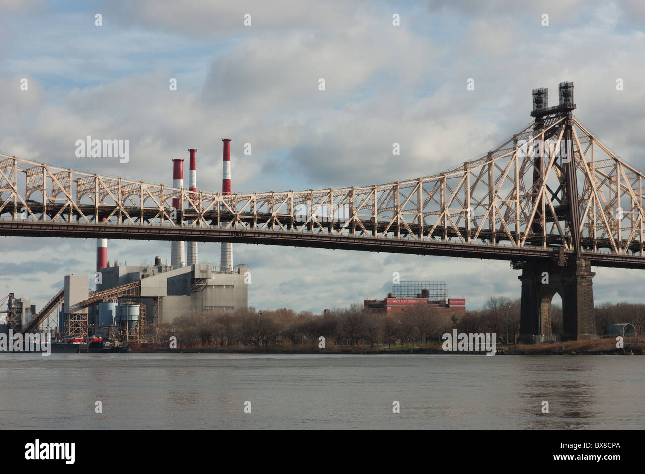 The Queensboro Bridge spans the East River with the Ravenswood Generating Station in the background in New York City. Stock Photo