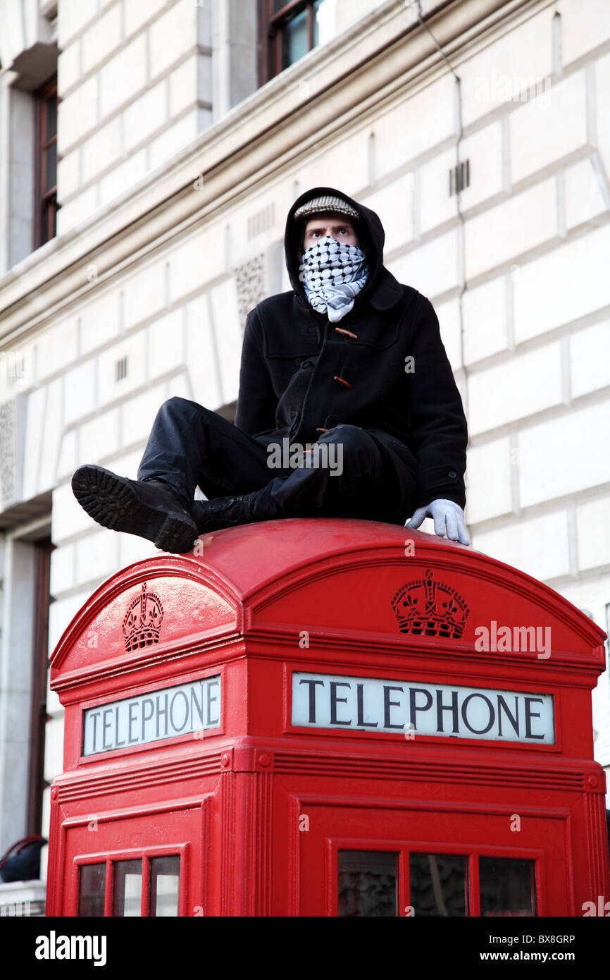 A student protester on top of a phone booth. Student protest. Parliament Square. Westminister. London Stock Photo