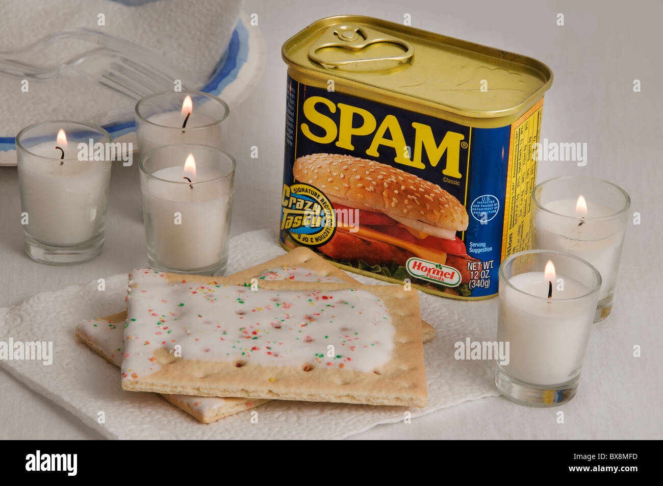 A can of Spam and frosted Pop-Tarts are served by candlelight during a memorable high sea adventure on a cruise ship. Stock Photo