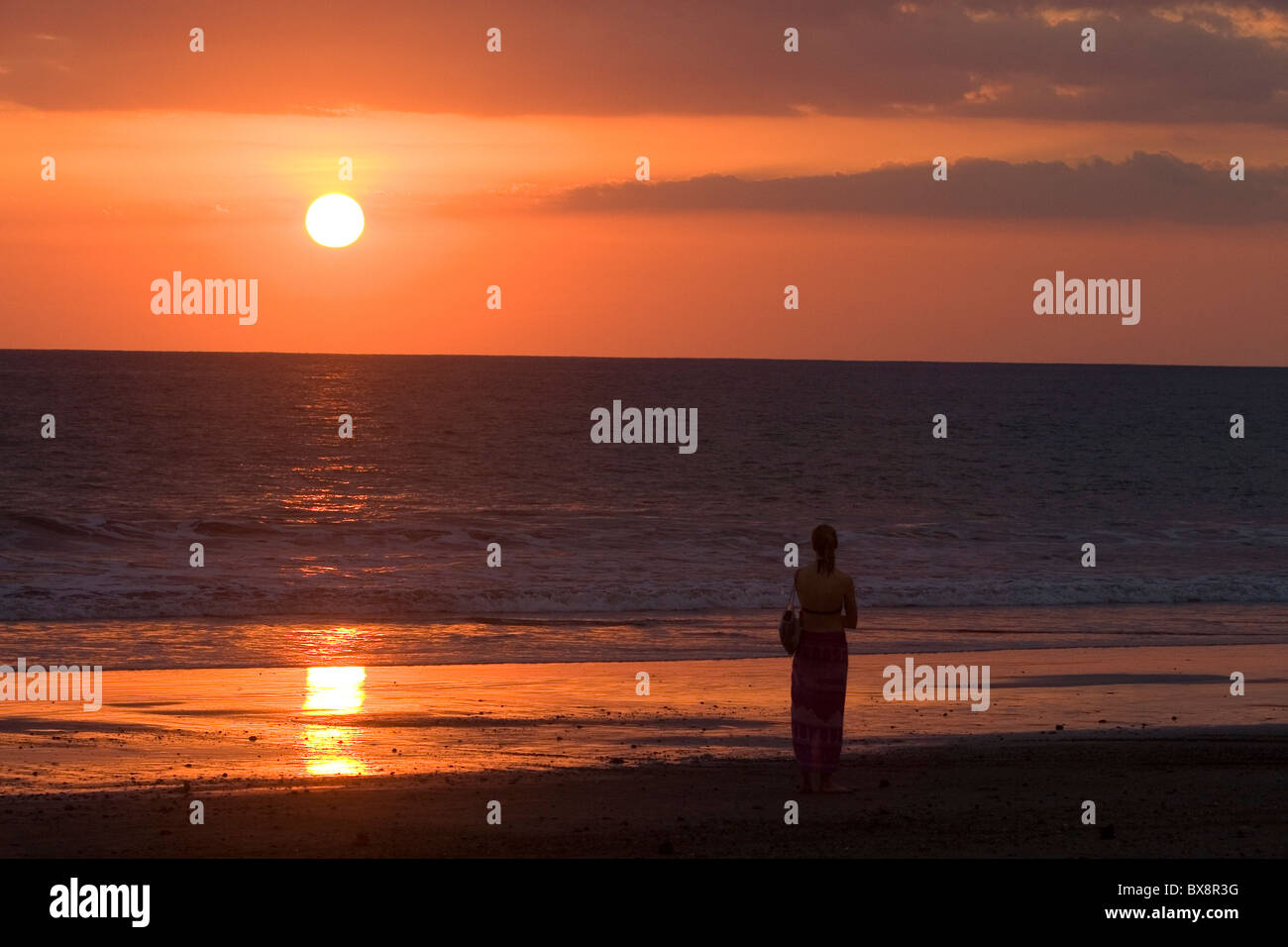 Person walking on the beach at sunset in the Manuel Antonio National Park in Puntarenas province, Costa Rica. Stock Photo