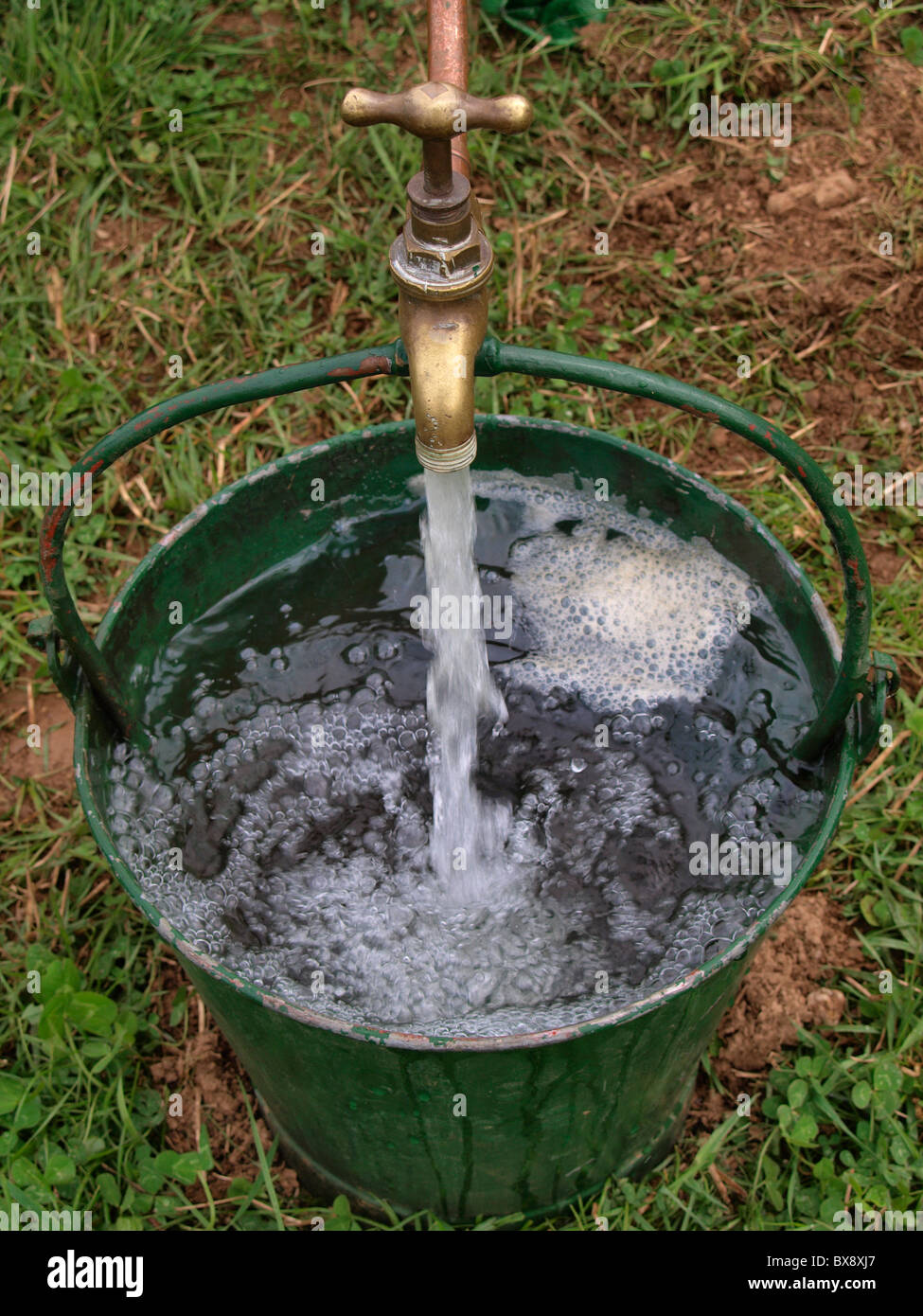 Bucket being filled with water, UK Stock Photo - Alamy