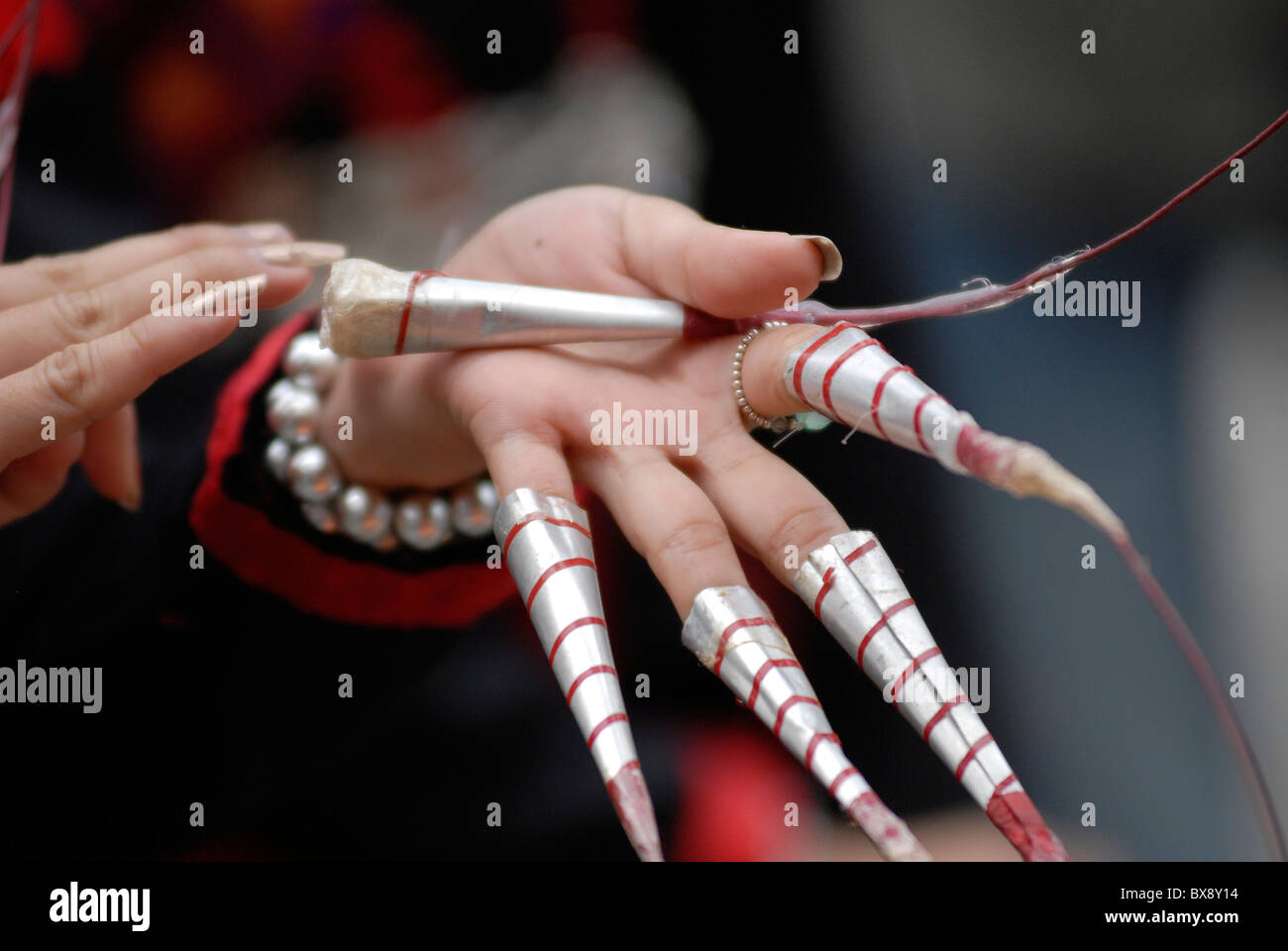 Thai female dancer wearing long metal finger cups before Fawn-Lep fingernail dance, Thailand Stock Photo