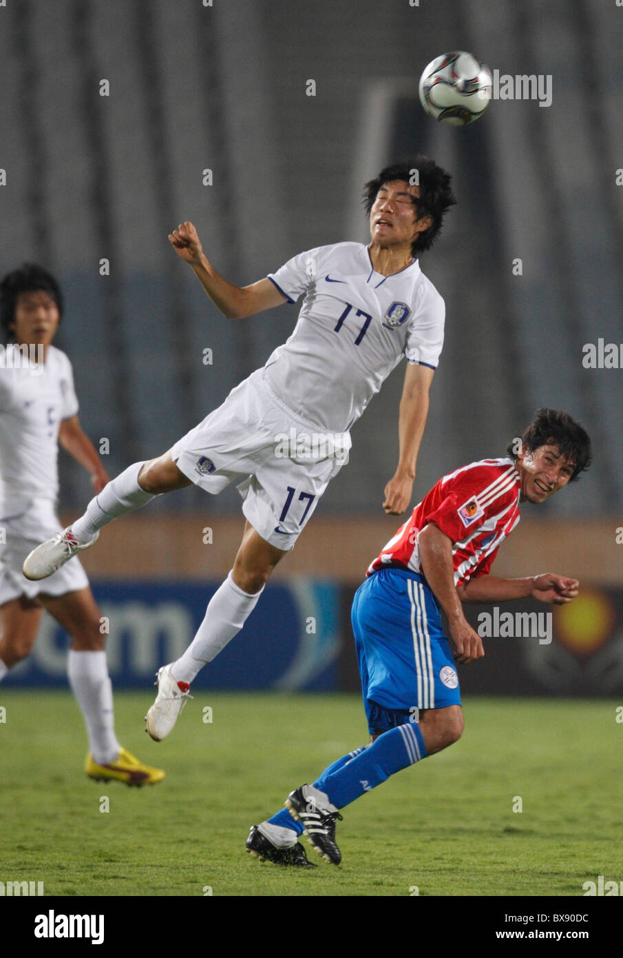 Suk Young Yun of South Korea (17) heads the ball over Hernan Perez of Paraguay during a 2009 U-20 World Cup round of 16 match. Stock Photo