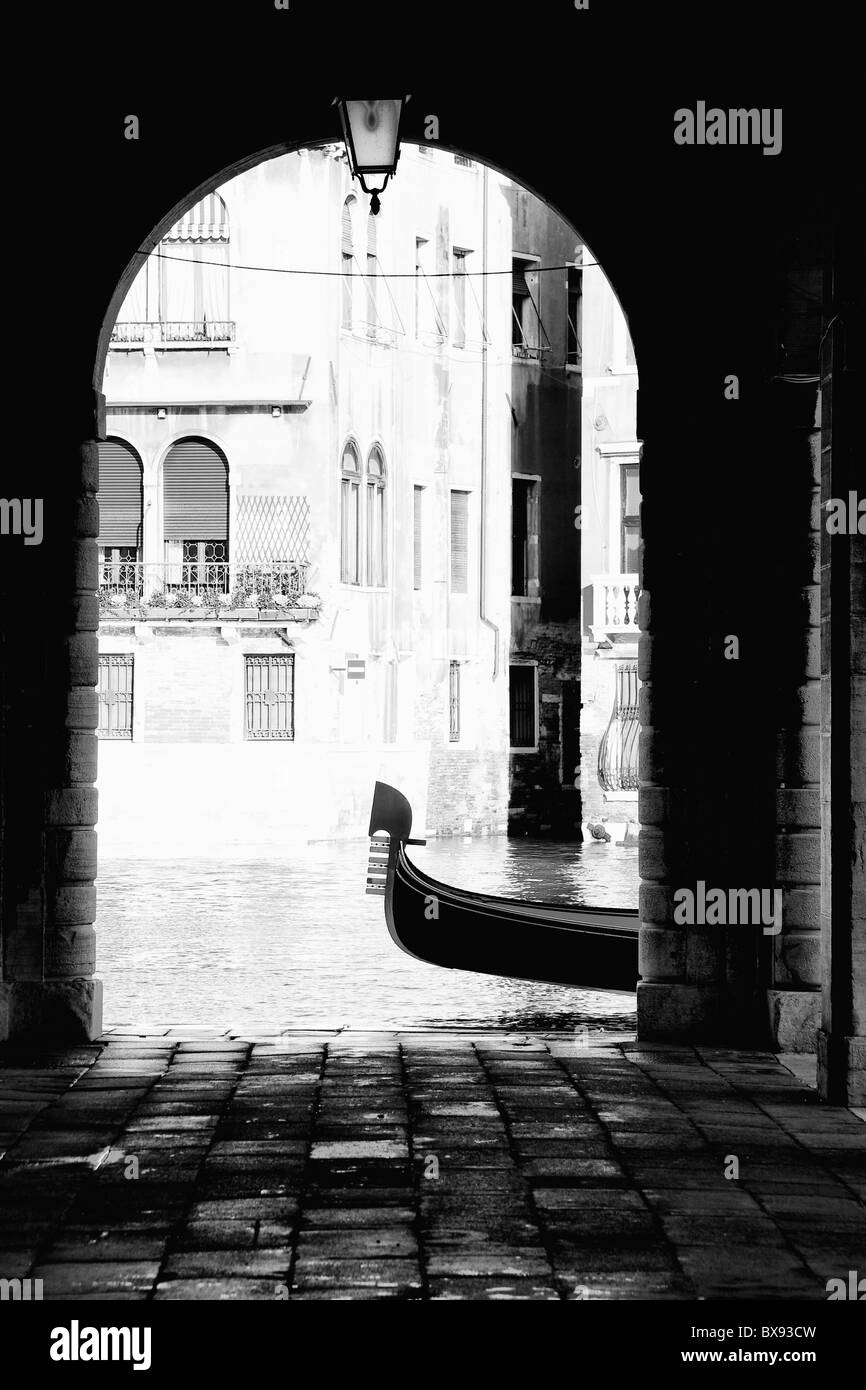 Gondola moored in Canal Grande framed by a venetian portico, Venice Stock Photo