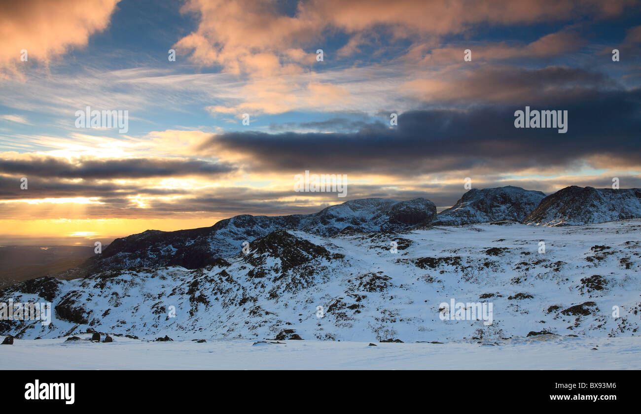 Winters day draws to a close, as the sun sets behind Scafell Pike, Englands Highest Mountain. Stock Photo