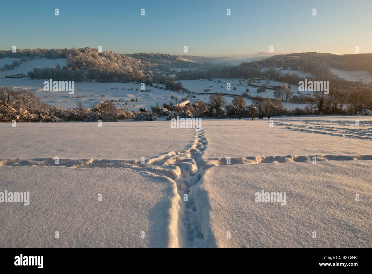 Cross paths in snow on hillside Warlingham looking over at Woldingham