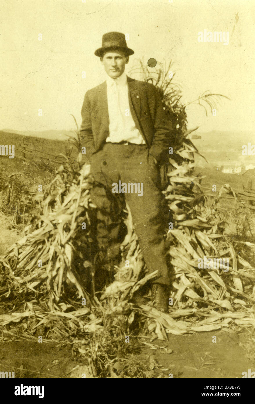 man standing next to corn stalks male portrait fashion hat black white shirt outdoors fall autumn corn Stock Photo