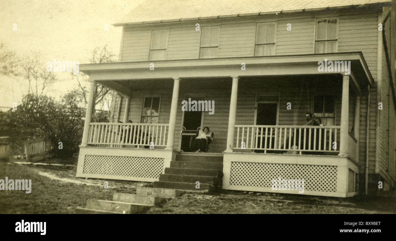 family members sitting on porch wooden architecture Americana black and white 1930s Stock Photo
