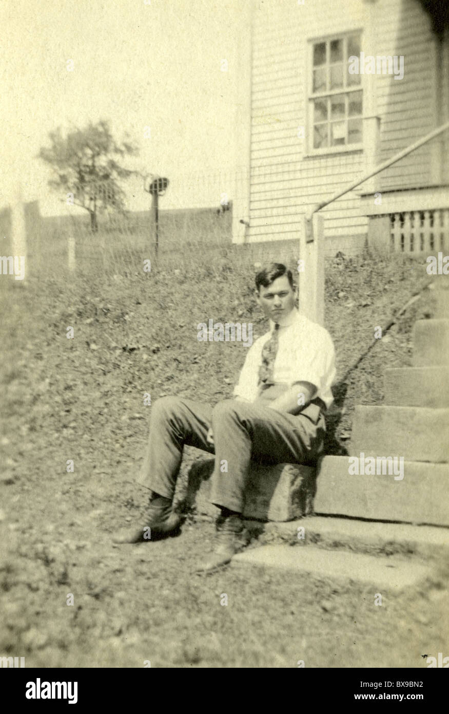 Man in his 20s sitting on steps of church. sunday religion christianity christian America 1930s 1920s Americana black and white Stock Photo