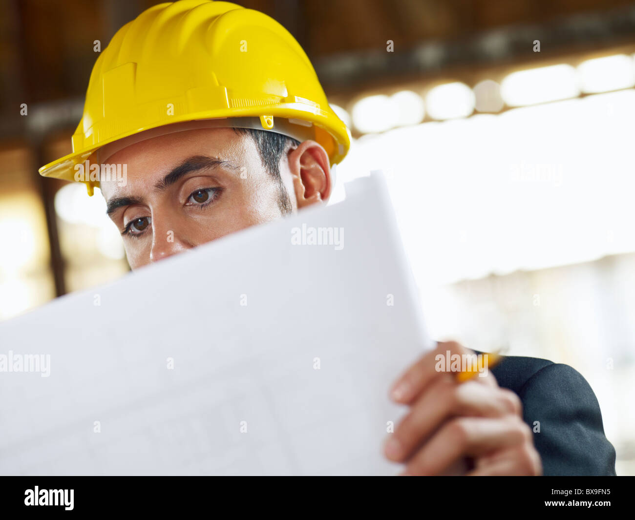 caucasian male architect examining blueprints. Horizontal shape, head and shoulders, front view, copy space Stock Photo