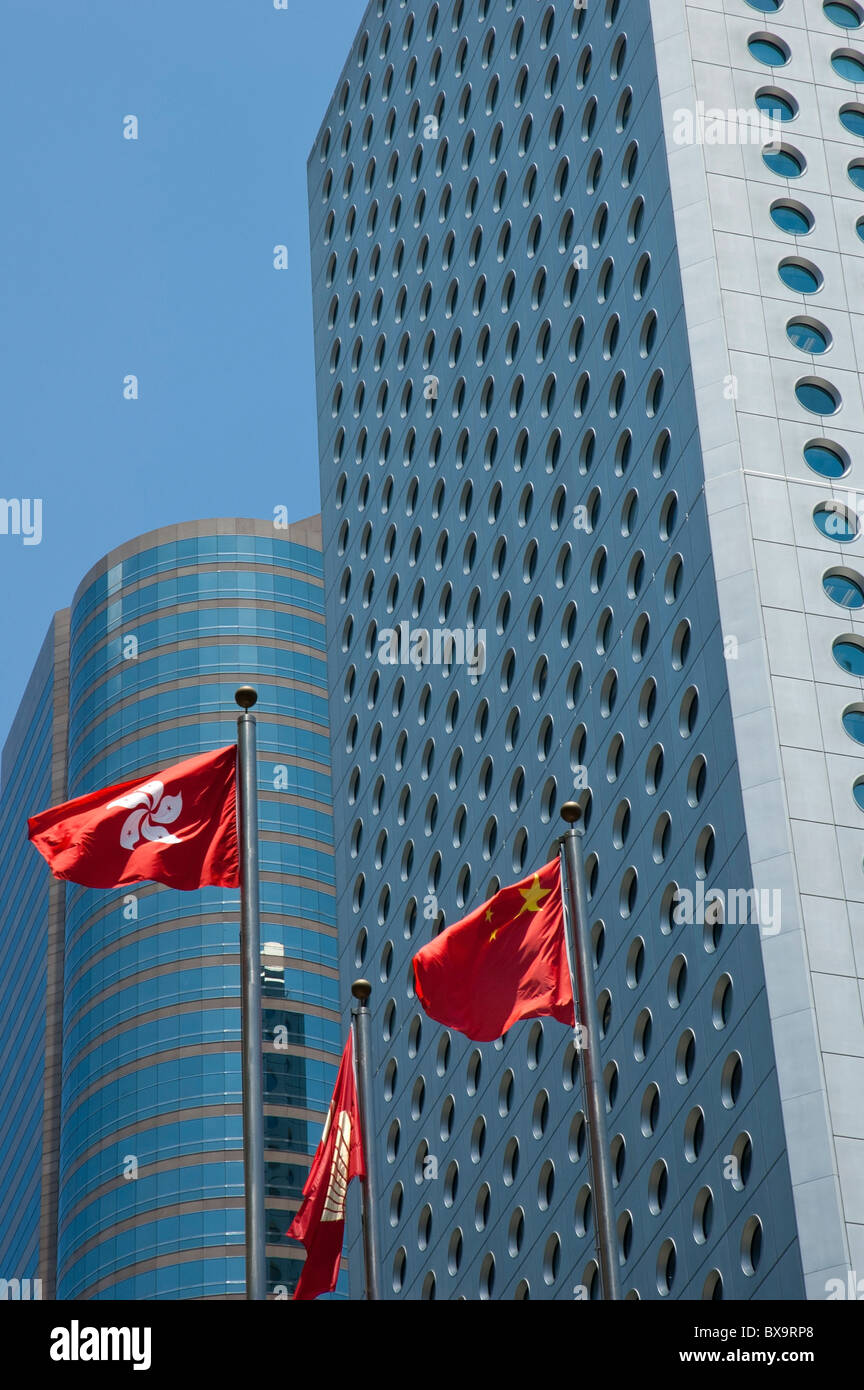 Chinese and Hong Kong district flags flying in front of modern skyscrapers, Hong Kong, China. Stock Photo