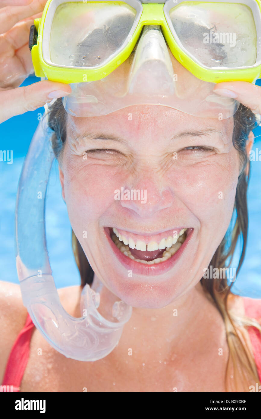 Woman coming out of the water wearing a snorkel and a big smile Stock