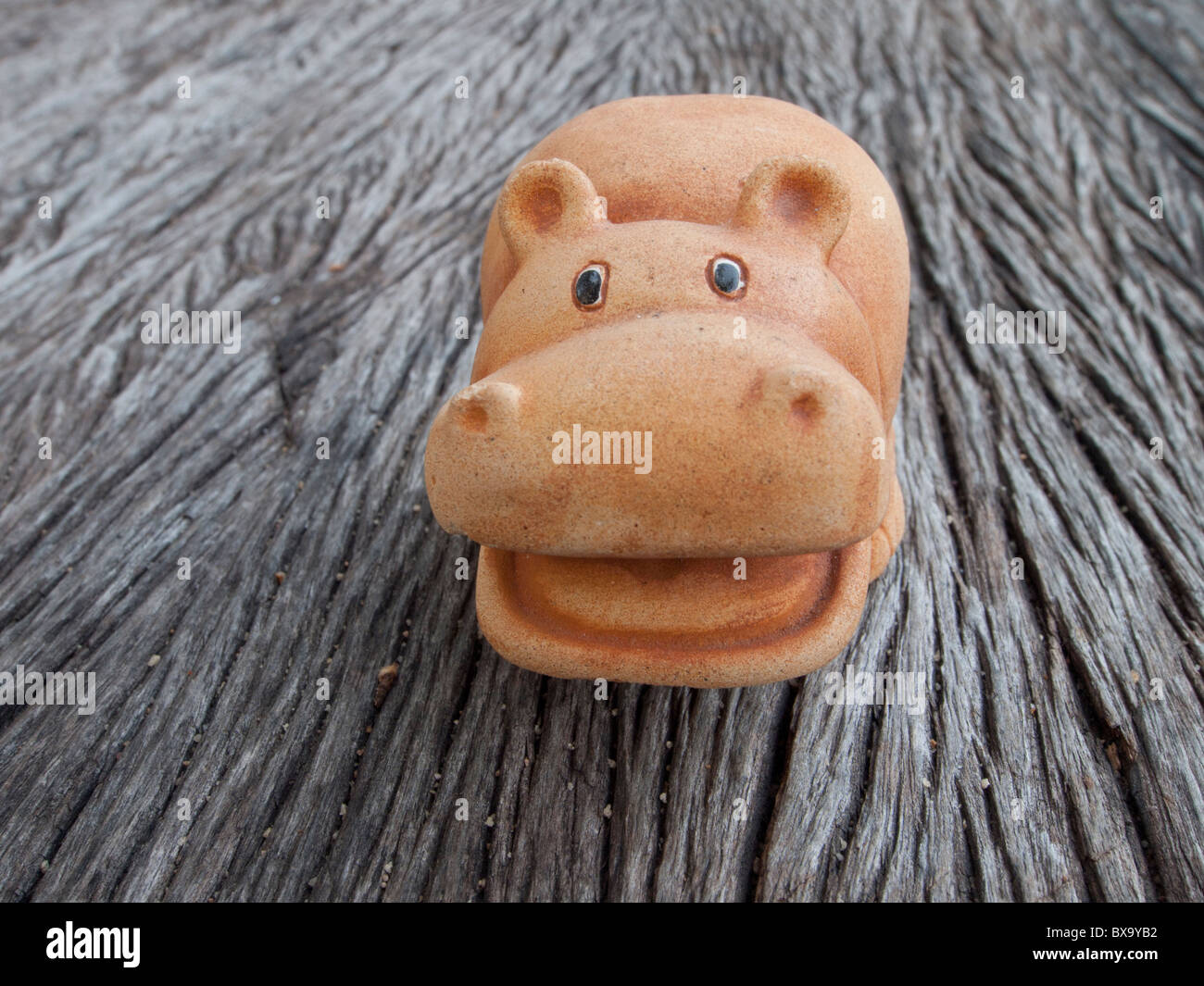 The hippopotamus Pottery for garden decoration sit on the old wood table Stock Photo