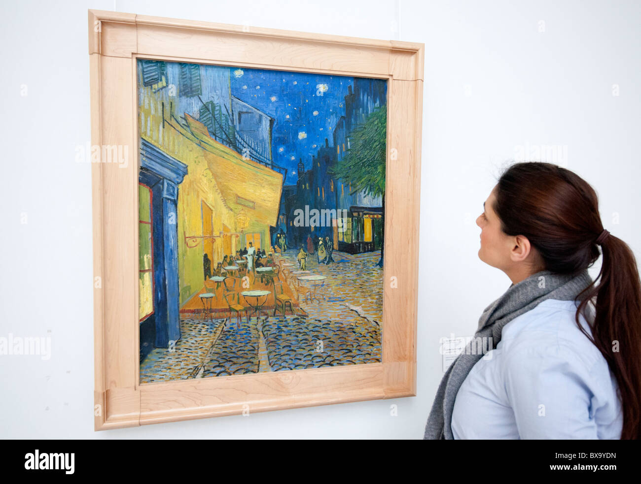 Woman looks at painting Terrace of a Cafe at Night (place du Forum) by Vincent van Gogh, Kroller-Muller Museum The Netherlands Stock Photo